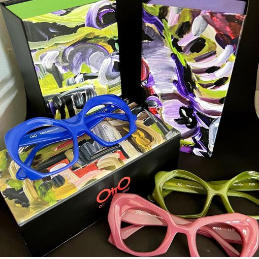 Expositor con funda y tres modelos de monturas de gafas en azul, verde y rosa.